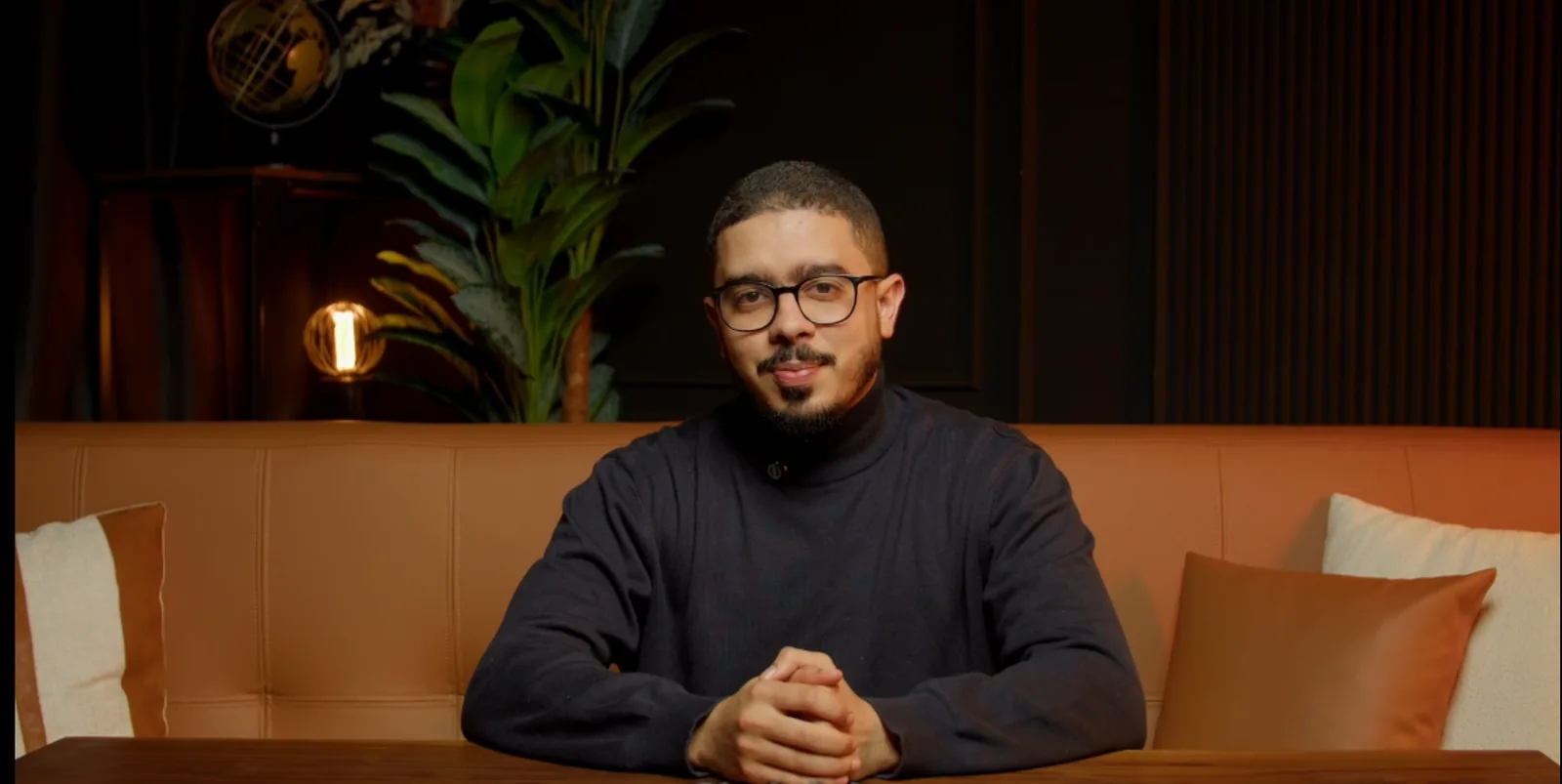 Ayman Kafi seated in his warmly lit studio